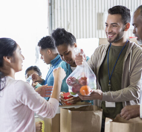 Group of food bank volunteers organizing donations with nonprofit insurance support.